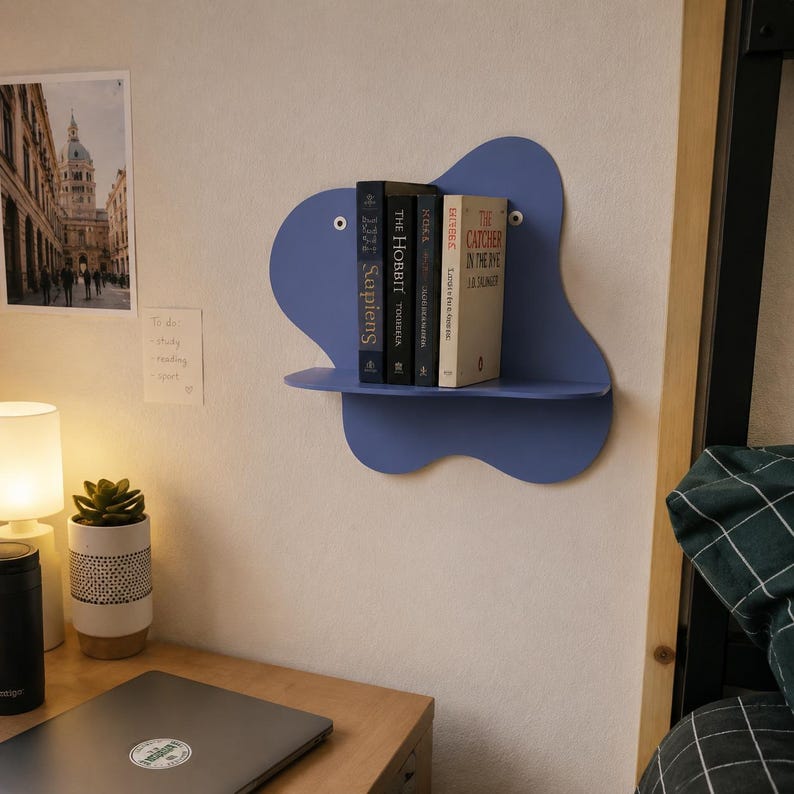 Abstract metal floating wall shelf with wavy back panel displaying a small vase and decorative dish