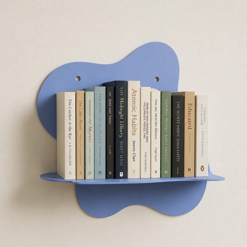 Abstract metal floating wall shelf with wavy back panel displaying a small vase and decorative dish