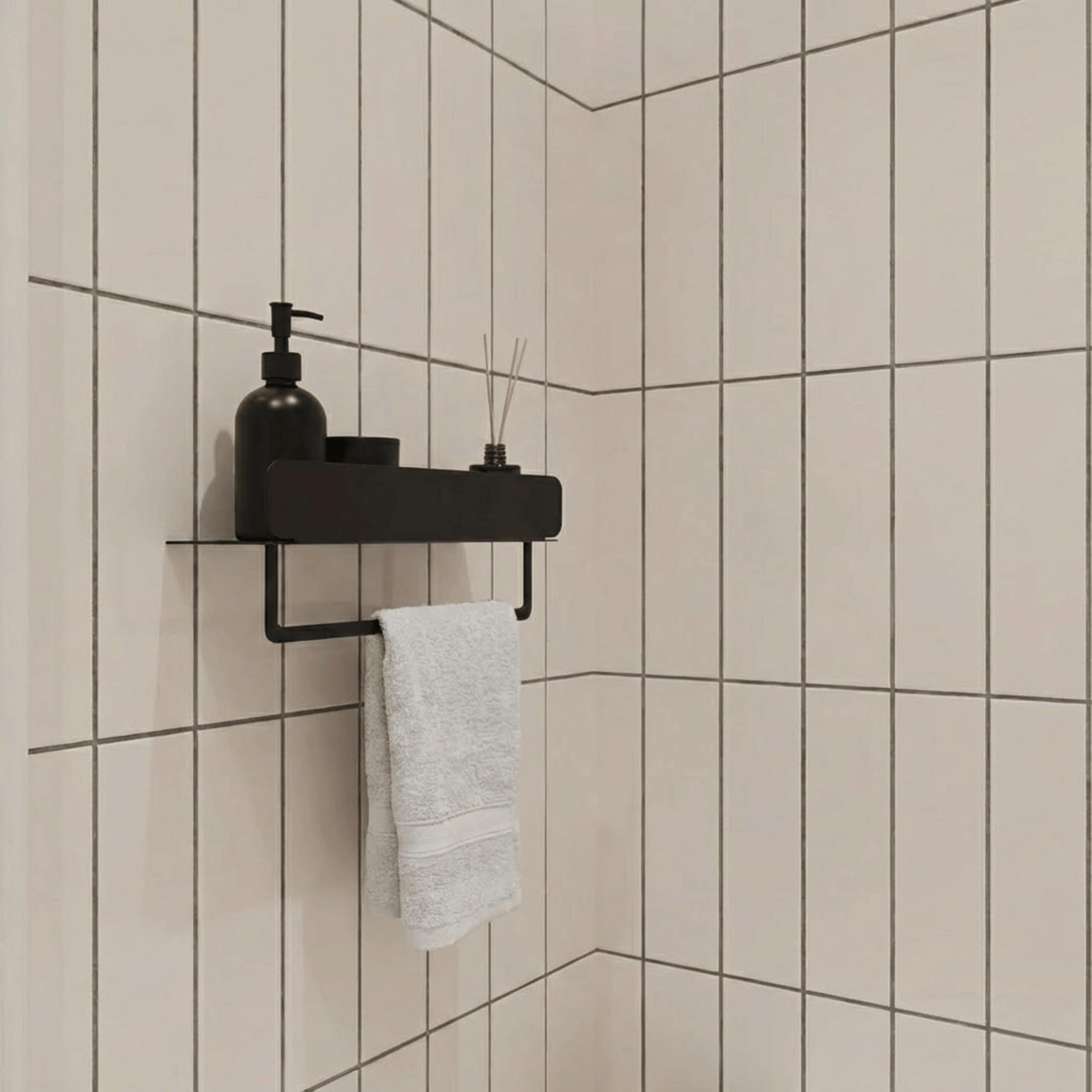 Bathroom corner with beige tiles, black shelf, and white towel.