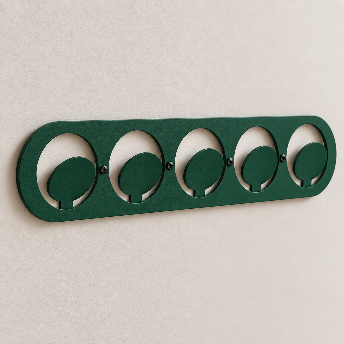 Dark green metal wall hook rack with circular hooks holding handbags in a modern entryway