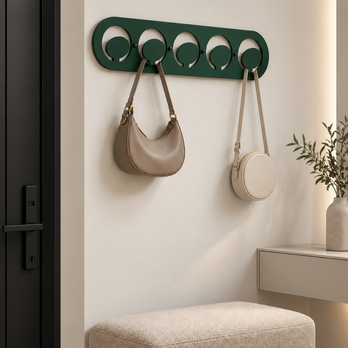 Dark green metal wall hook rack with circular hooks holding handbags in a modern entryway