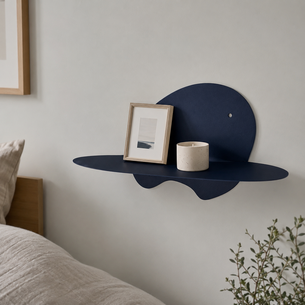  abstract metal floating wall shelf with curved back panel displaying a small succulent and notebook