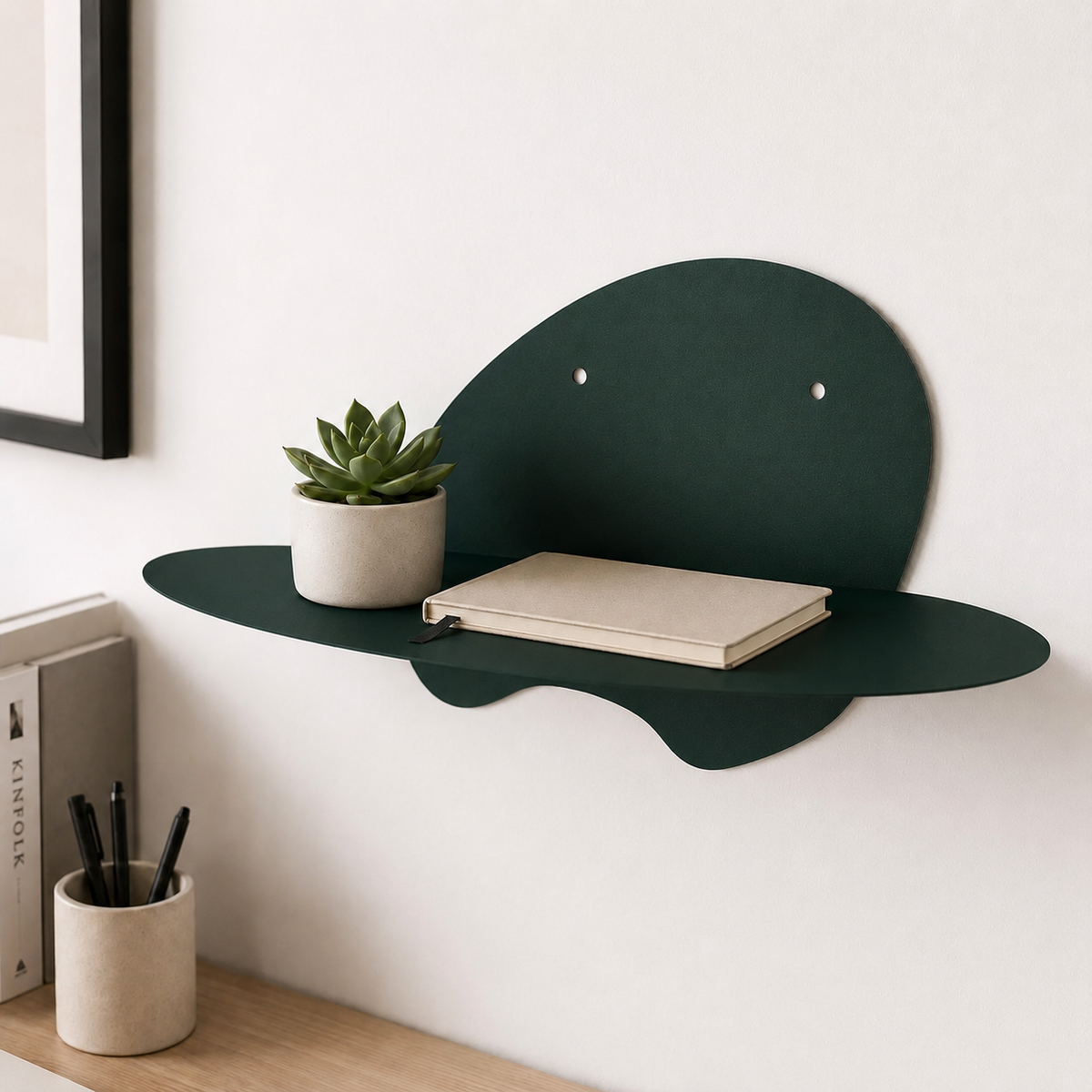  abstract metal floating wall shelf with curved back panel displaying a small succulent and notebook