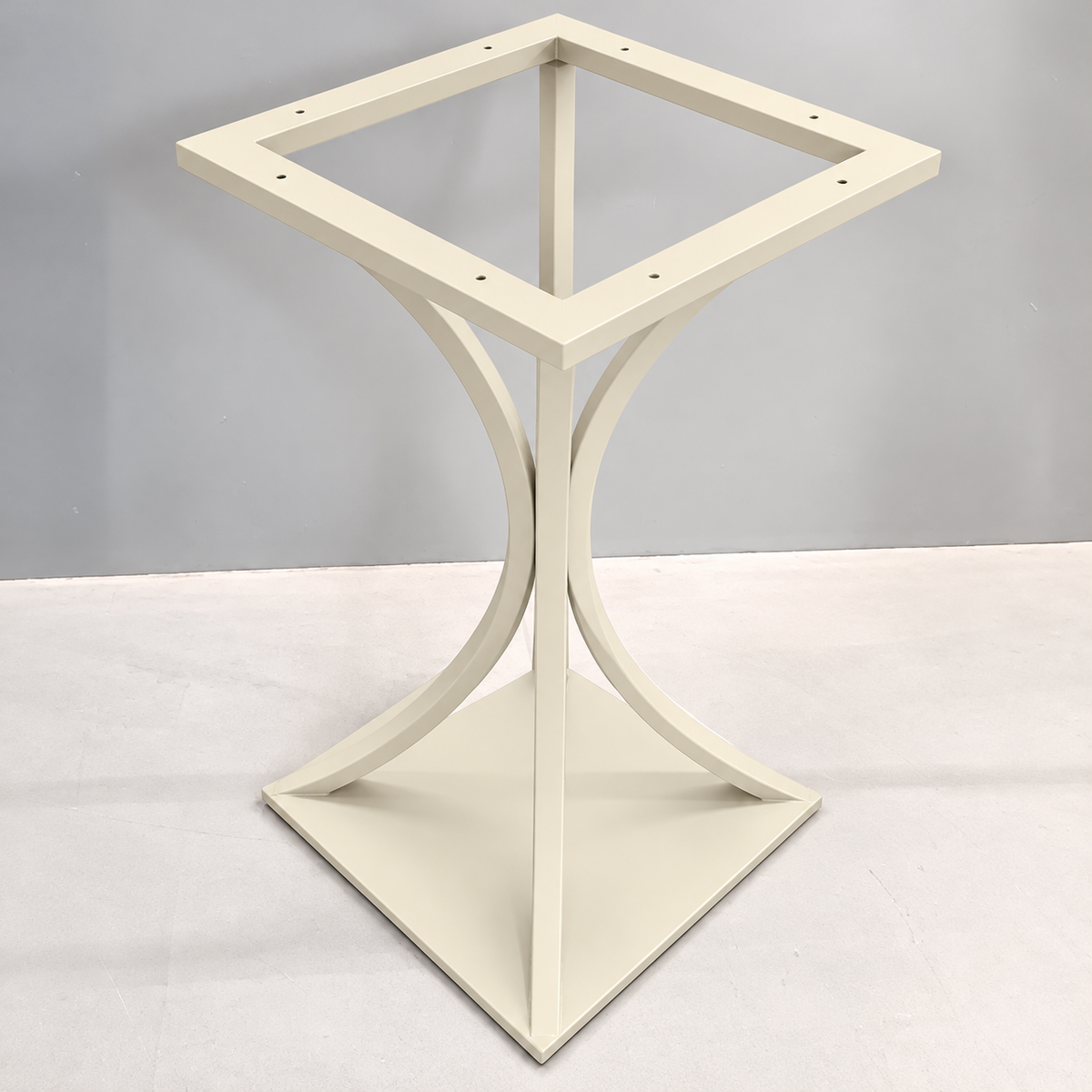 A square side table base with a diamond-shaped top frame and a sculptural curved pedestal base, finished in a warm cream or off-white color.