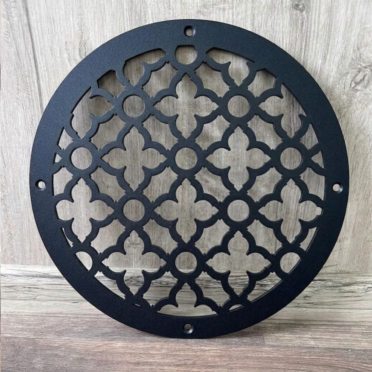 Round decorative metal vent cover with custom laser-cut pattern